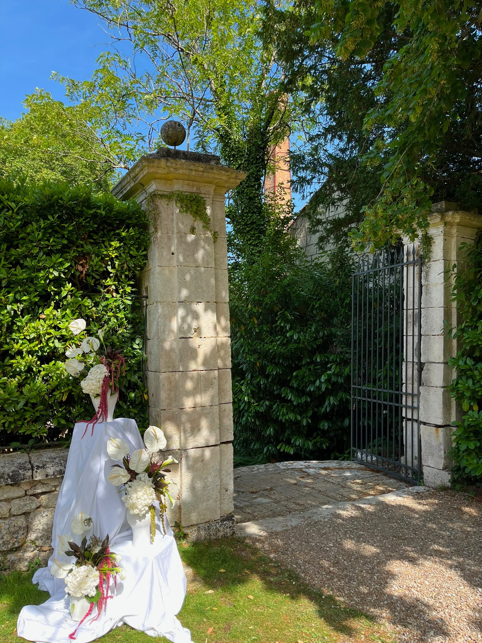 Le portail de pierre décoré de fleurs blanches
